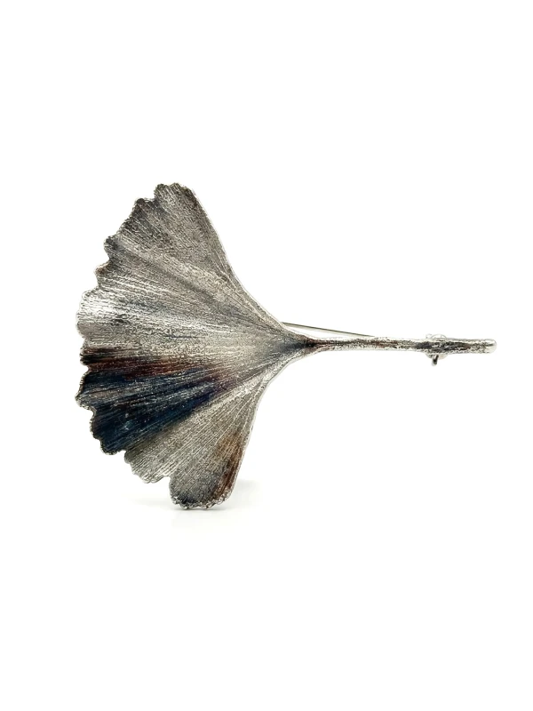 Srebrna broszka galwaniczna z prawdziwego liścia miłorzębu na białym tle