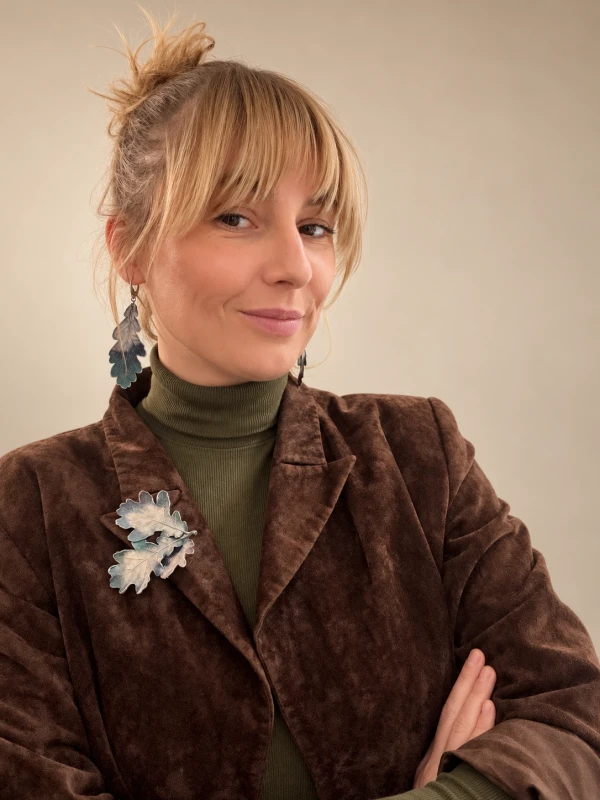 Portret blondynki z biżuterią liściastą.png