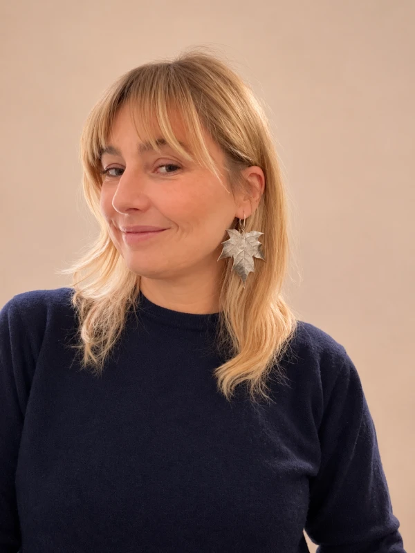 Portret blondynki ze srebrnymi kolczykami liśćmi.png